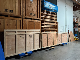 Custom-built wooden shipping crates on dollies inside a warehouse