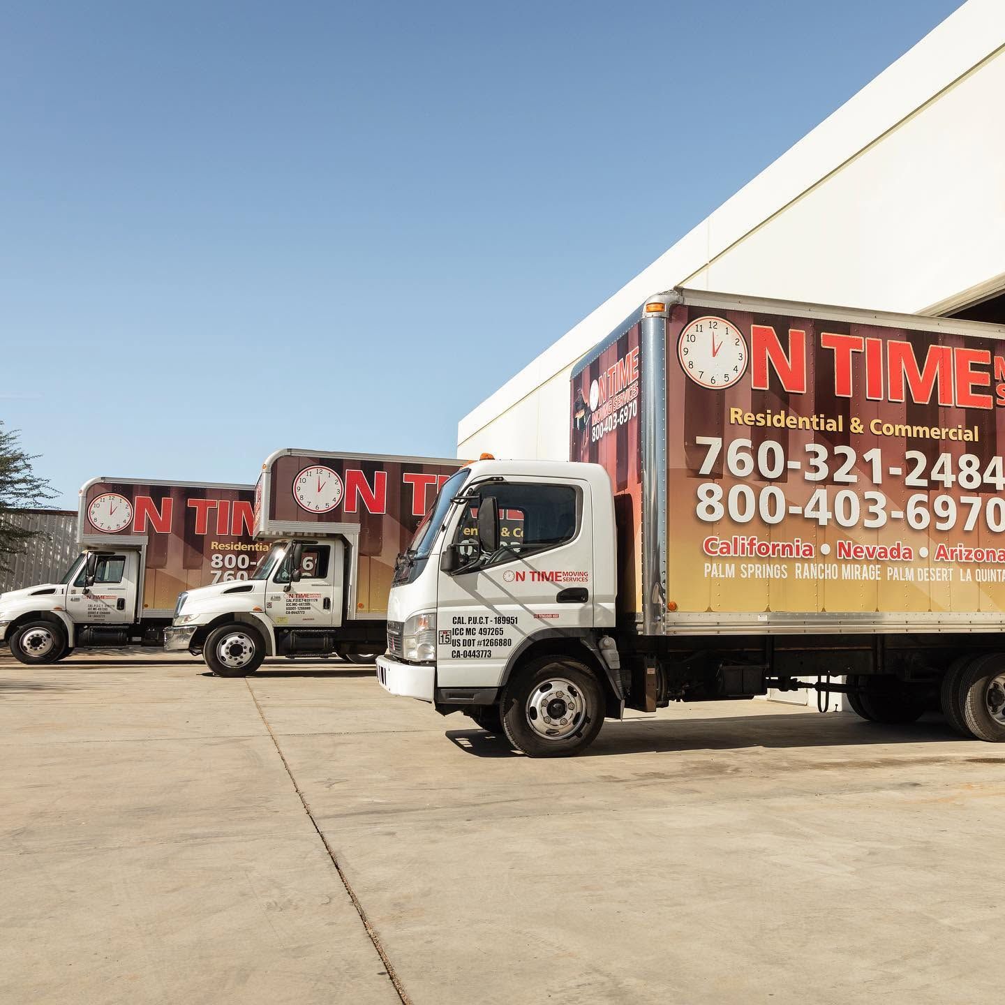 Three On Time Moving Services trucks parked in a row