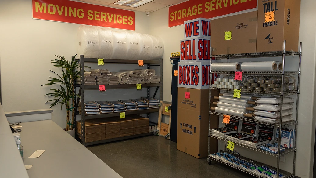 Warehouse shelving stocked with moving boxes, bubble wrap, and packing supplies