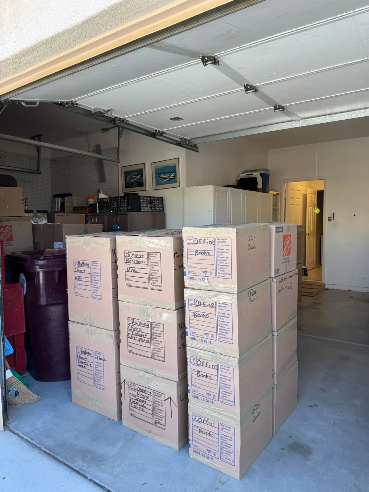 Stacks of labeled moving boxes organized in a garage during a move from Palm Desert to Banning.