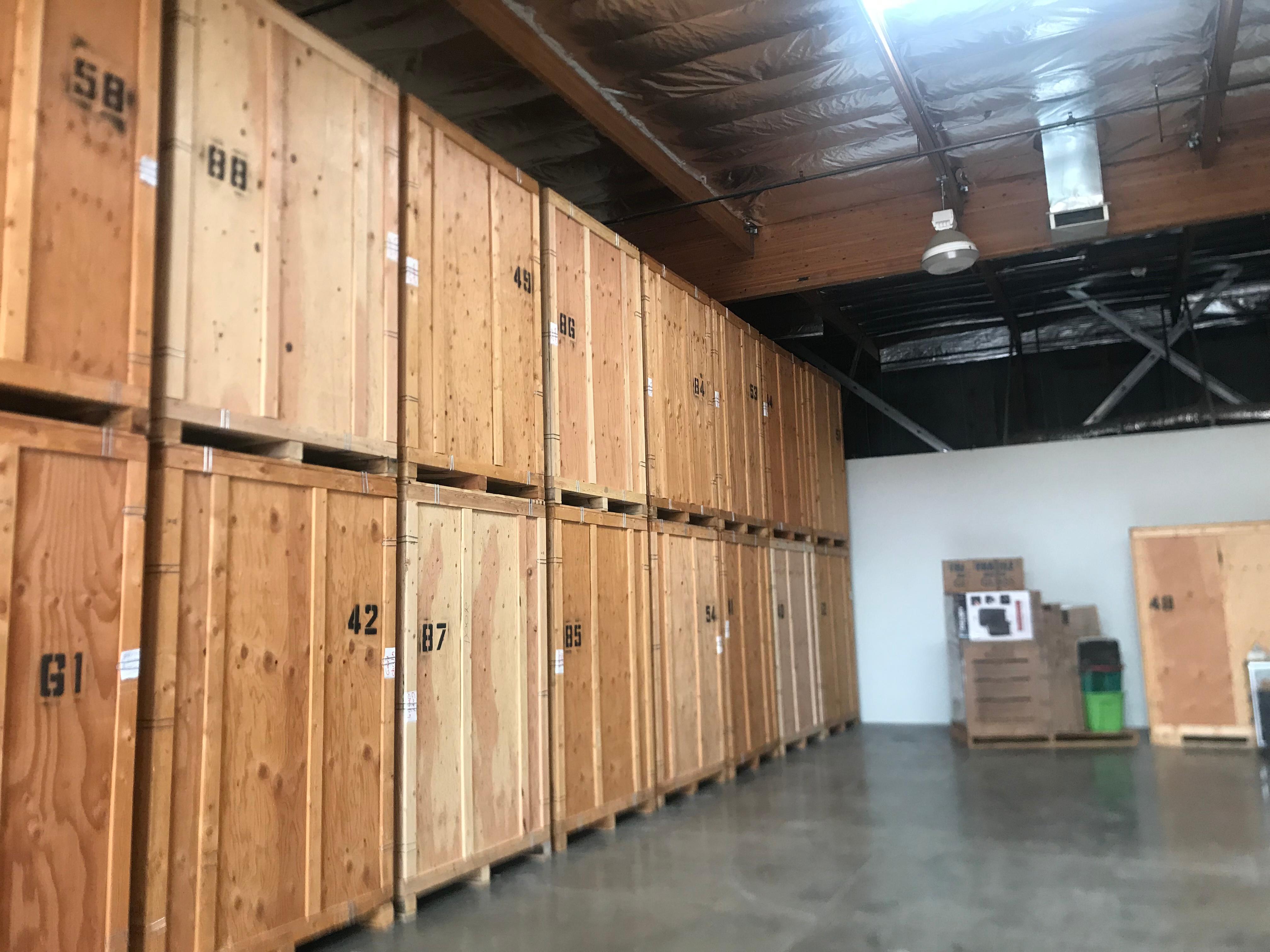 Warehouse interior with numbered wooden storage crates and a forklift